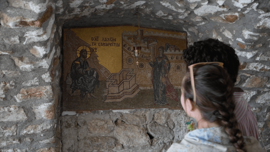 a woman looking at a mosaic on a wall