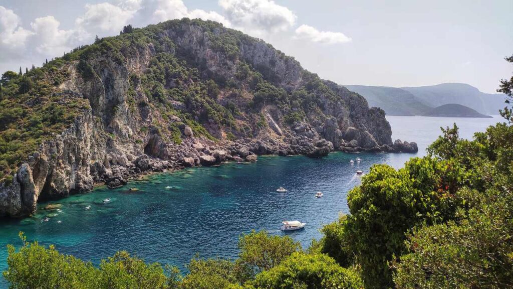 a rocky cliff and boats in the water