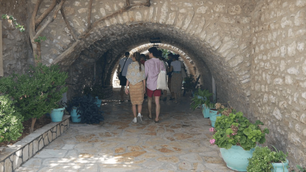people walking under a stone tunnel
